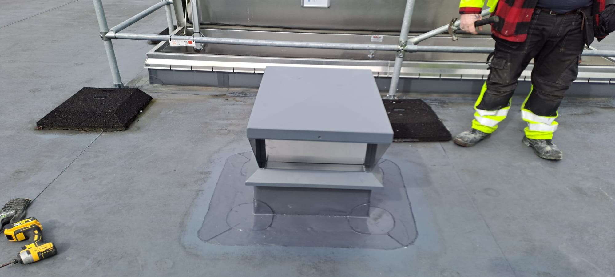 Rooftop installation with equipment and tools on site.