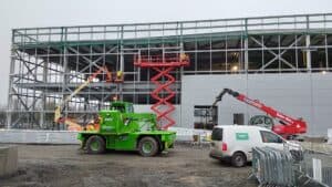Construction site with cranes and workers.